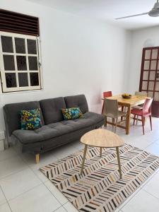 a living room with a couch and a table at Repaire des Alizés in Le Moule