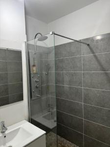 a bathroom with a glass shower with a sink at Repaire des Alizés in Le Moule +14 photos
