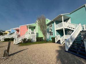 a row of colorful houses with stairs in front at Fiddler's Restaurant and Resort in Steinhatchee