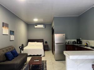 a living room with a bed and a kitchen at Apartamentos zafiro in Bahia
