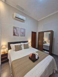 a bedroom with a large white bed and a mirror at Casa Alves Próx Hospital do Amor Com Suíte e Ar in Barretos +16 photos