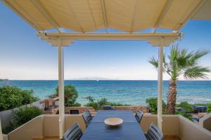 a patio with a blue table and chairs and the ocean at Plaka Studios in Karfas