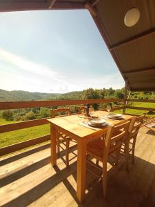 a wooden table and chairs on a deck with a view at Glamping Podere Poggiagrilli in San Gervasio