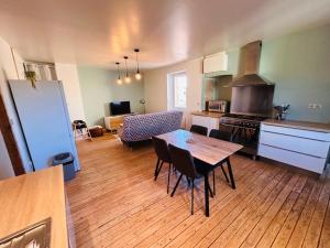 a kitchen and living room with a table and chairs at Gîte de l'auberge in Lupé