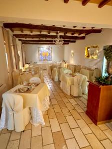 een restaurant met witte tafels en een kroonluchter bij La Siègià Resort spa in Massa Marittima +115 foto's