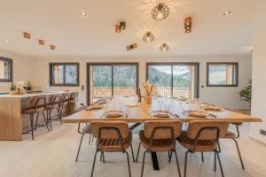 a large dining room with a large wooden table and chairs at Chalet APY - Grand chalet neuf avec terrasse, 6 chambres en-suite , wifi, balcon, etc in Les Gets