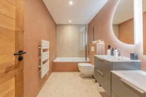 a bathroom with a toilet and a sink and a tub at Chalet APY - Grand chalet neuf avec terrasse, 6 chambres en-suite , wifi, balcon, etc in Les Gets +47 photos