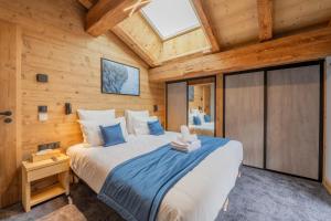 a bedroom with a large bed in a wooden cabin at Chalet APY - Grand chalet neuf avec terrasse, 6 chambres en-suite , wifi, balcon, etc in Les Gets