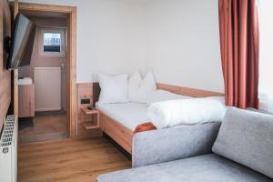 een woonkamer met een bed en een bank bij die Harmonie in Nauders