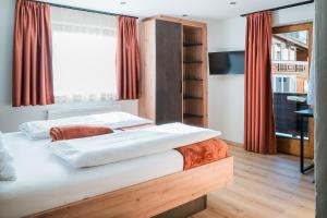 twee bedden in een kamer met rode gordijnen bij die Harmonie in Nauders +40 foto's