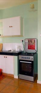 a kitchen with a stove and white cabinets at Makasembo breeze homes in Kisumu