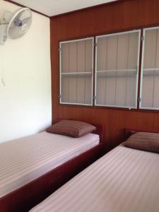 two twin beds in a room with windows at Sea Gate Beach Resort in Thongsala