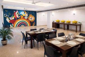 a restaurant with tables and chairs and a rainbow mural at EMBLEM Hotel - Arjun Marg, Golf Course Road, Gurgaon in Gurgaon