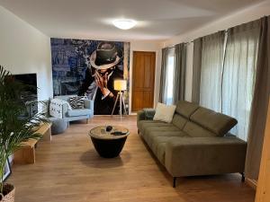 ein Wohnzimmer mit einem Sofa und einem Hut an der Wand in der Unterkunft Green House kuća s 4 spavaće sobe in Stara Sušica