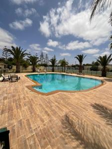 a swimming pool in a courtyard with palm trees at Villa Prestige avec piscine in Tamaris