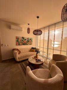 a living room with a couch and a table at Salguero Suites - Playa Salguero - By INMOBILIARIA VS in Santa Marta