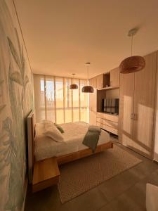 a bedroom with a bed and a large window at Salguero Suites - Playa Salguero - By INMOBILIARIA VS in Santa Marta