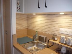 een keuken met een spoelbak en een aanrechtblad bij Au gré des marées, 2 chambres in Hanvec