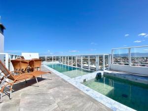 a balcony with a swimming pool on top of a building at Studio Capão - novo com piscina e rooftop in Capão da Canoa