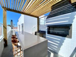 a kitchen with a counter and a counter top at Studio Capão - novo com piscina e rooftop in Capão da Canoa