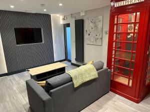 a living room with a couch and a red phone booth at 6Adelphi in Preston +10 photos