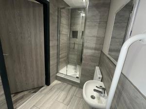 ein Badezimmer mit einem weißen Waschbecken und einer Dusche in der Unterkunft 6Adelphi in Preston + 11 Fotos