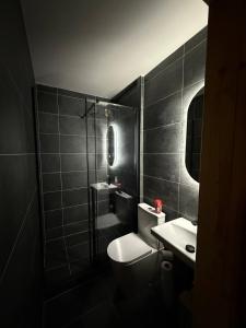a black bathroom with a toilet and a sink at Chata u Karla in Rudná pod Pradědem