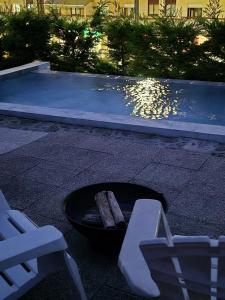 a fire pit with a bench next to a swimming pool at Casa da Figueira in Guilhufe