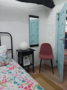 a bedroom with a bed and a chair and a mirror at Casa da Figueira in Guilhufe +22 photos