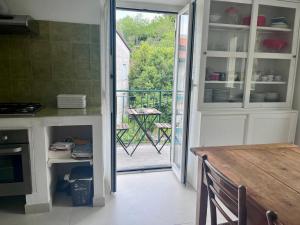 a kitchen with a table and a view of a balcony at The Palm House in Santa Margherita Ligure