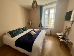a bedroom with a bed with a blue blanket and a window at Le colibri bleu in Argeliers
