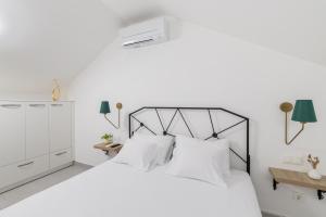 a white bedroom with a large white bed with white pillows at Bogić kuća in Zavala
