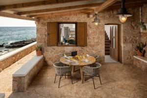 a table and chairs on a patio next to the ocean at Bogić kuća in Zavala