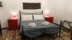 a bedroom with a bed with two towels on it at La Casa Vecchia in Nuraminis