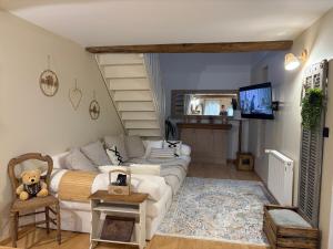 a living room with a couch and a tv at Petit cocon à 5 min de Sedan in Sedan
