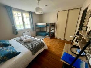 a bedroom with a bed and a room with a desk at Le colibri bleu in Argeliers