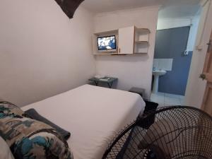 a small room with a bed and a tv at Montclair Forest Guest House in Durban
