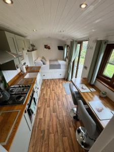 a kitchen and dining area of a tiny house at Fullabrook Farm Retreat, The Shepherdess Hut in West Down