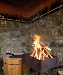 博尔若米Family hotel mountain panorama的火坑,配有酒杯和葡萄酒瓶