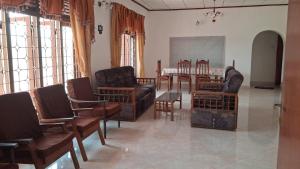 a living room with leather chairs and a dining room at WIJAYA Rest in Gampaha