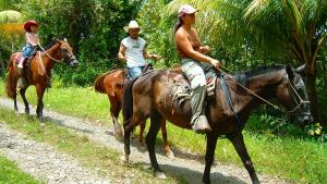 Quelques personnes à cheval sur un chemin de terre dans l'établissement LagunaVista Villas, à Carate