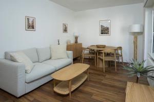 a living room with a couch and a table at Maraini Deluxe Apartment - free parking in Massagno