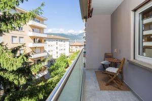 a balcony with a chair and a view of a building at Maraini Deluxe Apartment - free parking in Massagno