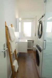 a bathroom with a sink and a washing machine at Maraini Deluxe Apartment - free parking in Massagno