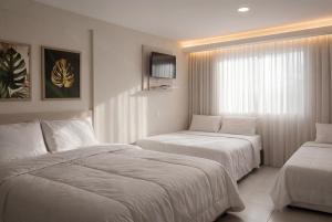 una camera d'albergo con due letti e una finestra di Pousada Estrela Dourada a João Pessoa