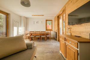 una cucina e una sala da pranzo con divano e tavolo di Baitèl - Tra il cielo e le Alpi a Gromo
