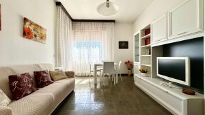 a living room with a couch and a television at SE081 - Comodo trilocale a Marotta in Marotta