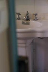 ブローニュ・シュル・メールにあるLe relais de saint Jacquesの白いバスルームの洗面台(2つの蛇口付)