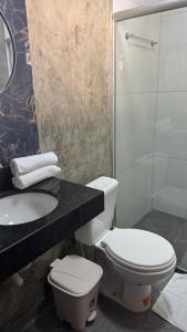a bathroom with a toilet and a sink and a shower at Bangalô em uma área próxima a praia e centro in Porto Seguro +5 photos