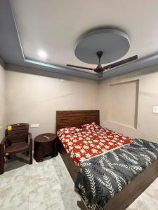 a bedroom with a bed and a chair and a ceiling at Laxmi Dham Guest House in Chhatikara